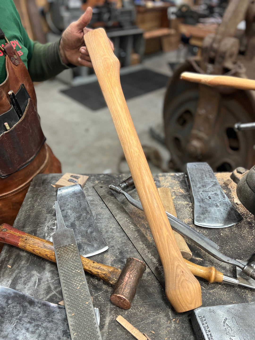 Close up of a polished hickory wood axe handle with engraved details and textured grip